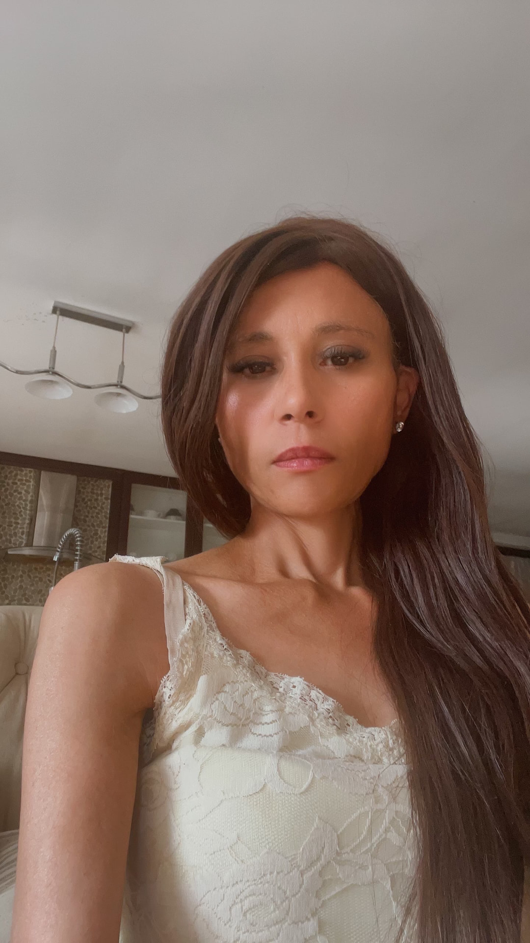 Cass in an ivory lace cami — soft brown eye, glossy nude lip, long tousled hair